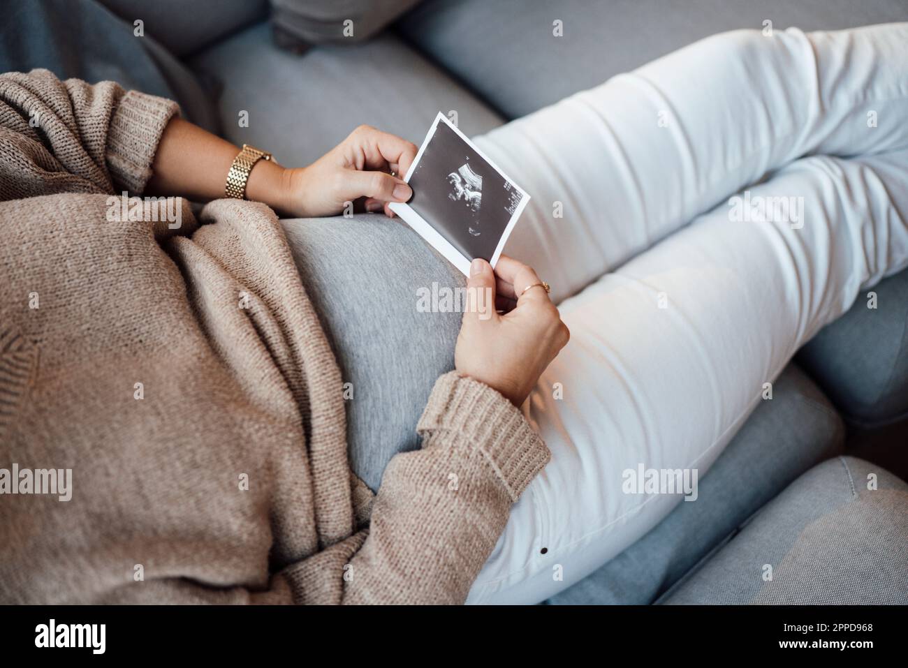 Schwangere Frau mit Ultraschallfoto zu Hause Stockfoto