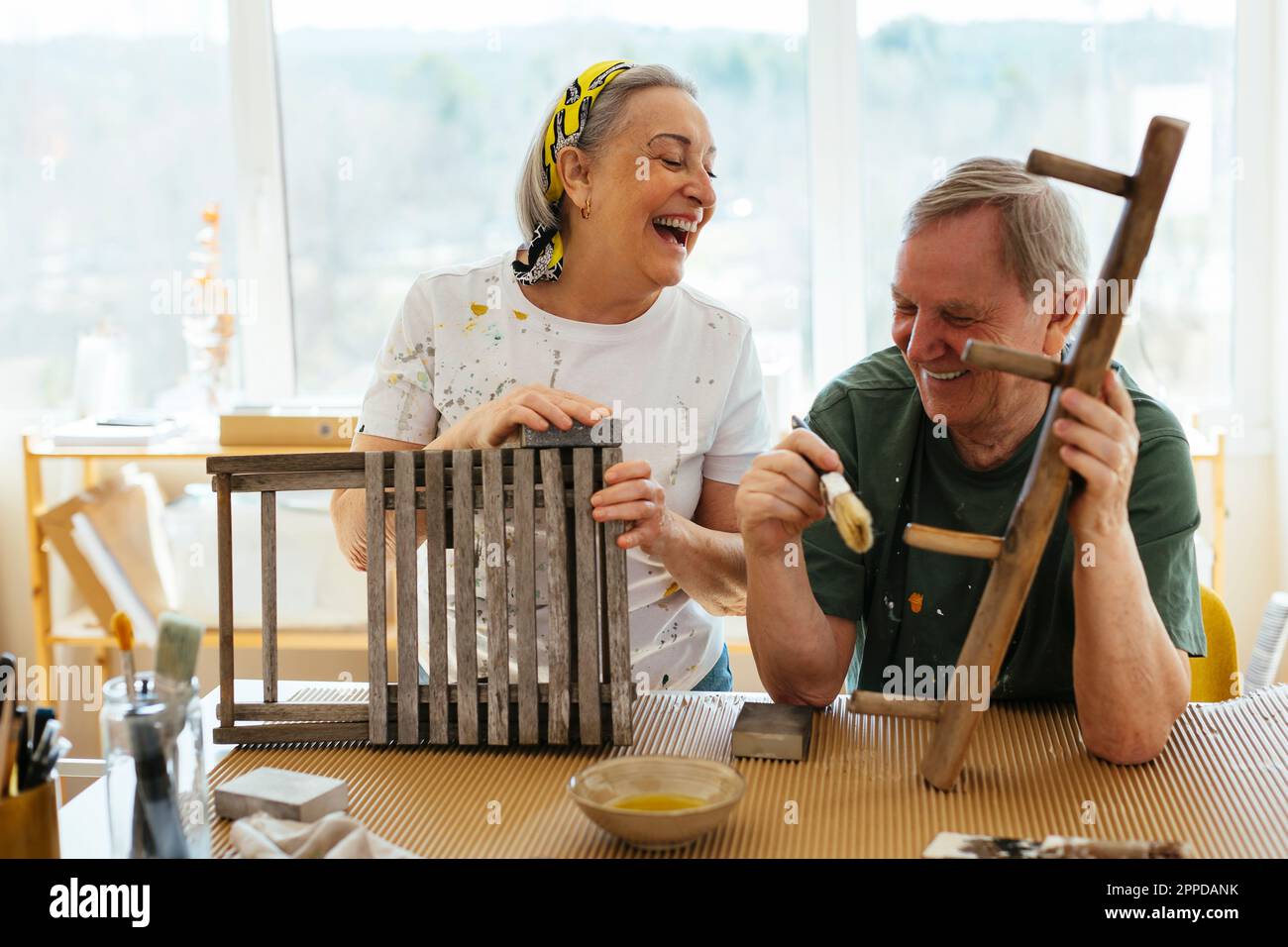 Glückliches Seniorenpaar, das sich in der Werkstatt amüsiert Stockfoto