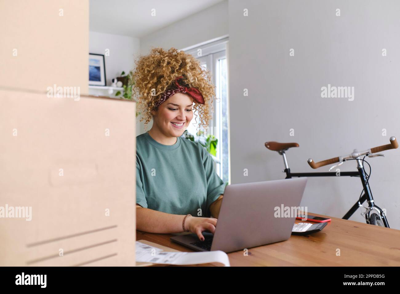Glückliche junge Geschäftsfrau auf Laptop am Schreibtisch arbeiten Stockfoto