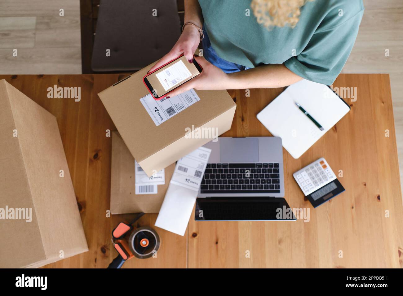 Junge Frau fotografiert Etiketten mit Smartphone Stockfoto