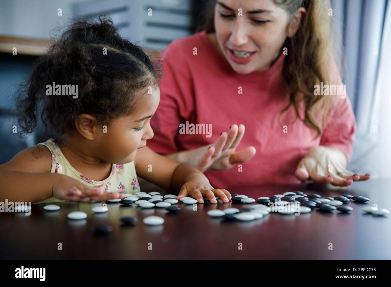 Mutter spielt Go-Game mit Tochter zu Hause auf dem Tisch Stockfoto