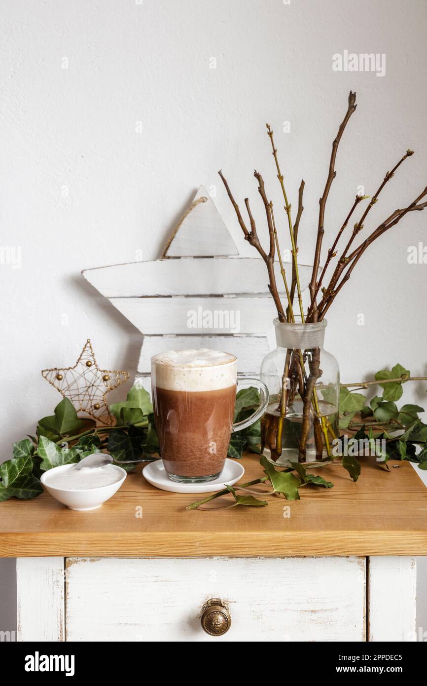 Tasse mit heißer Schokolade und Weihnachtsdekorationen stehen auf dem Nachttisch Stockfoto