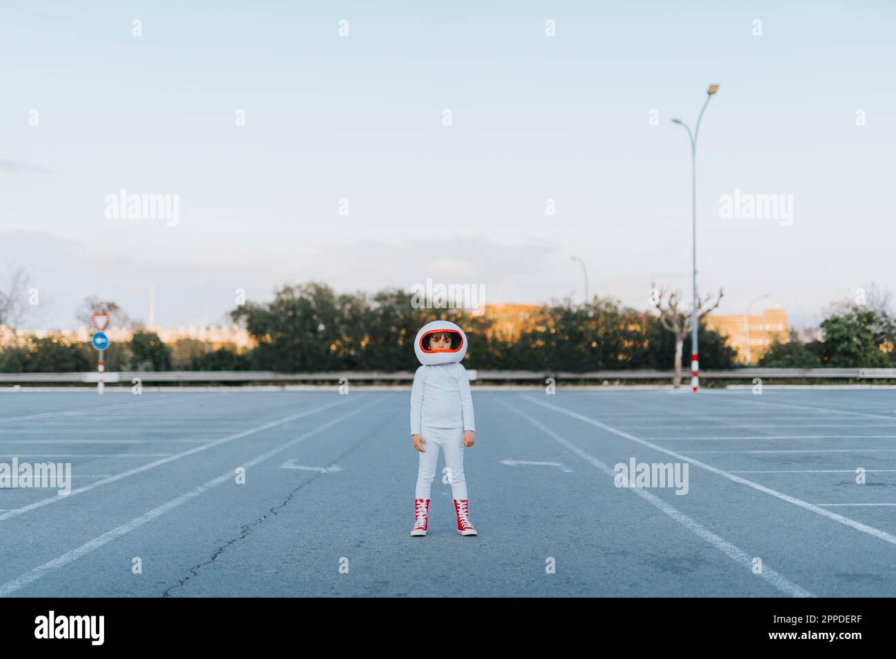 Ein Mädchen, das als Astronautin verkleidet auf dem Parkplatz steht Stockfoto