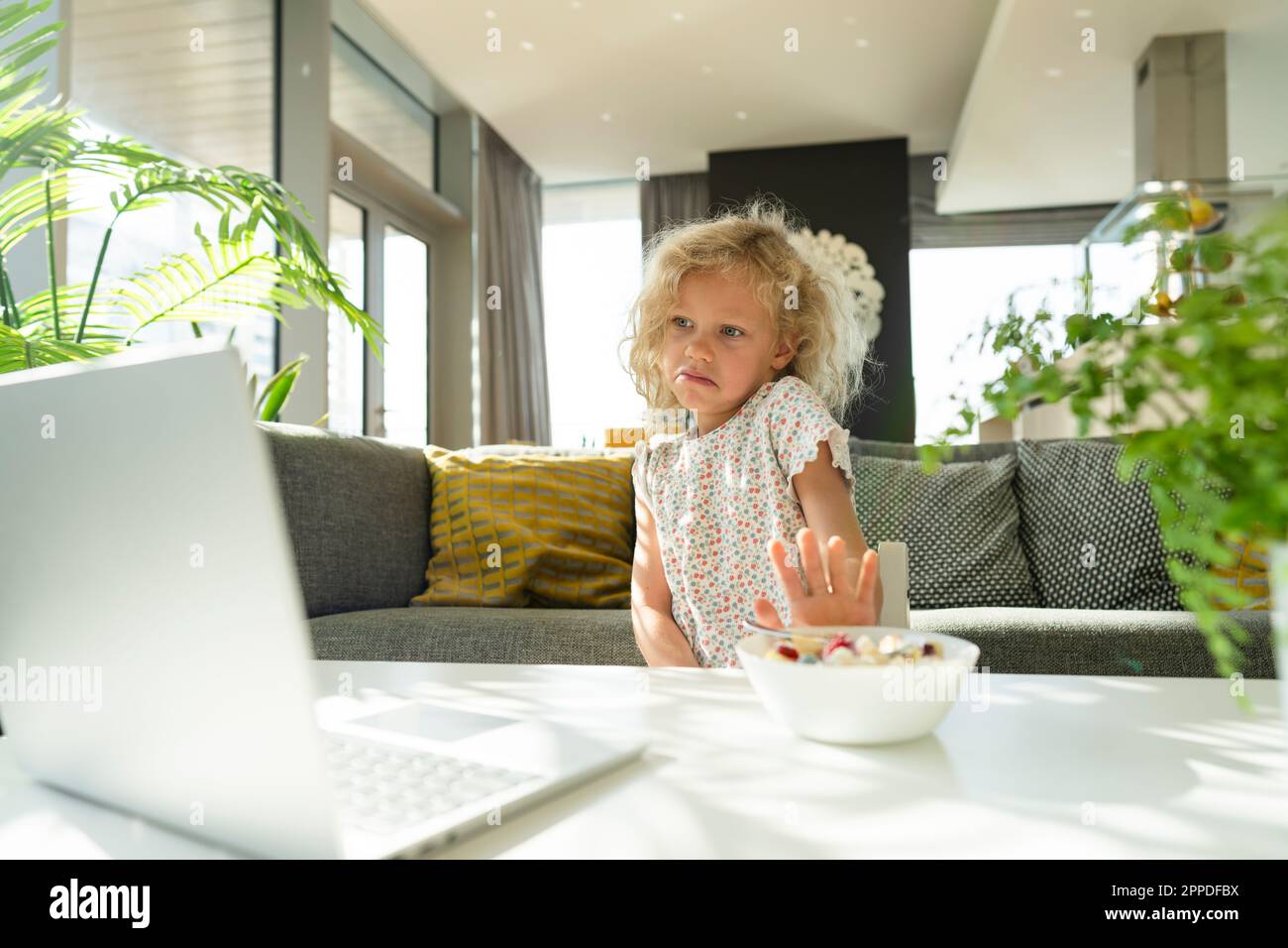 Ein Mädchen weigert sich, zu Hause auf dem Laptop zu sitzen Stockfoto