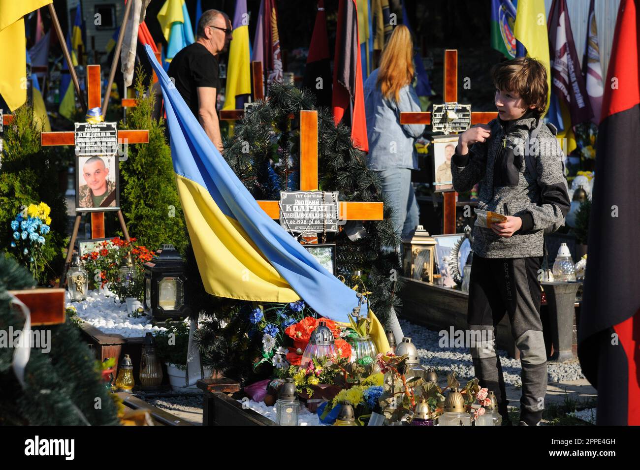 Lemberg, Ukraine. 23. April 2023. Ein Junge steht am Grab eines ukrainischen Helden auf dem Marsfeld auf dem Friedhof Lychakiv. Die Menschen besuchen die gefallenen Helden der Ukraine, die das Territorium der Ukraine auf dem Friedhof Lychakiv verteidigten, wo sie begraben sind. Russland marschierte am 24. Februar 2022 in die Ukraine ein und löste damit den größten militärischen Angriff in Europa seit dem Zweiten Weltkrieg aus (Foto: Mykola Tys/SOPA Images/Sipa USA) Guthaben: SIPA USA/Alamy Live News Stockfoto