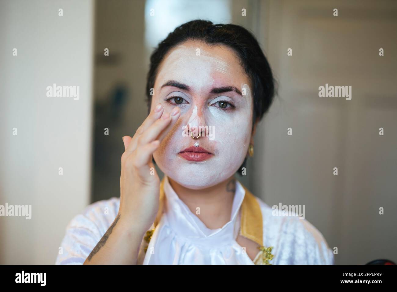 Eine Frau, die an Halloween ihr Gesicht malt Stockfoto