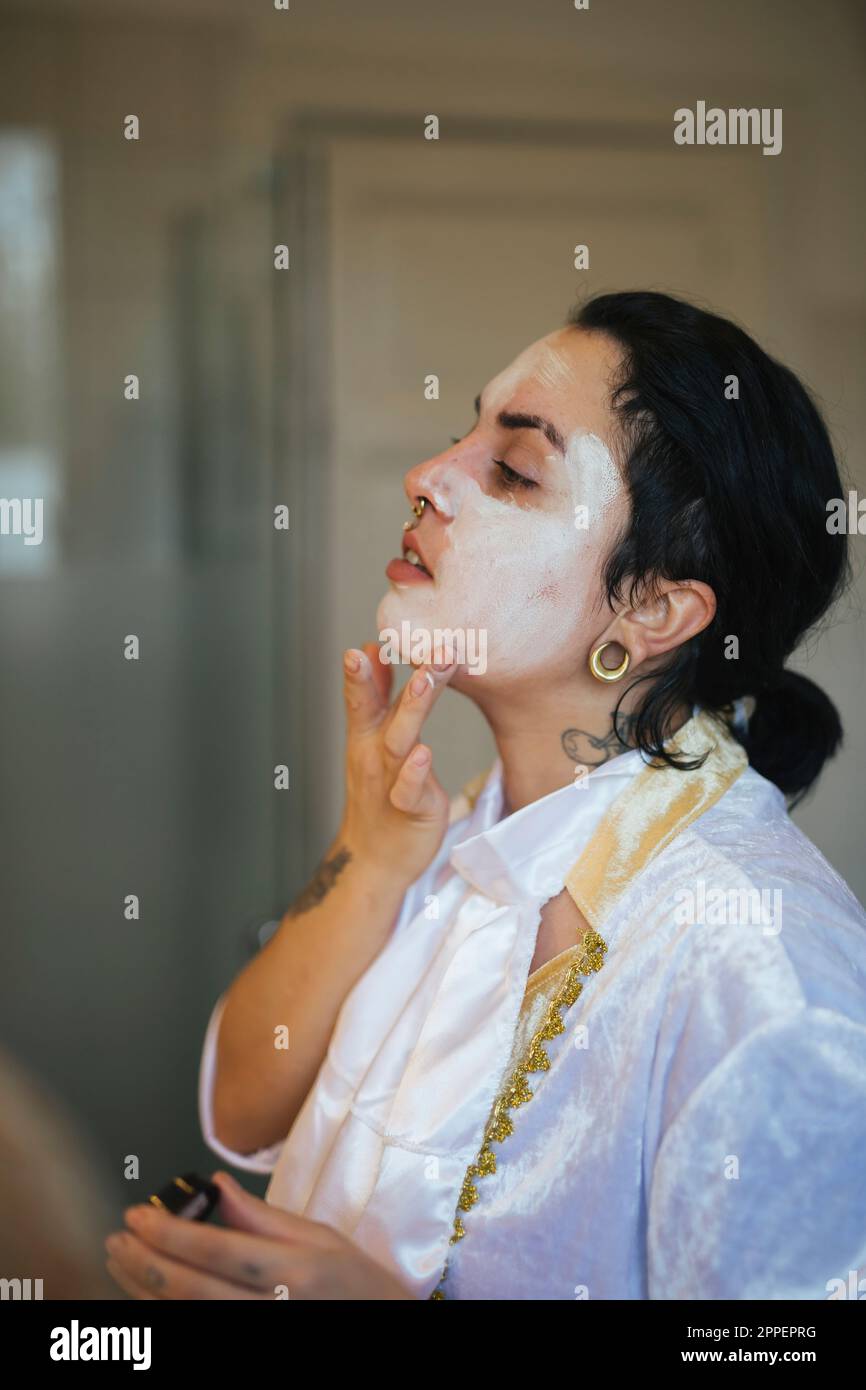 Eine Frau, die an Halloween ihr Gesicht malt Stockfoto