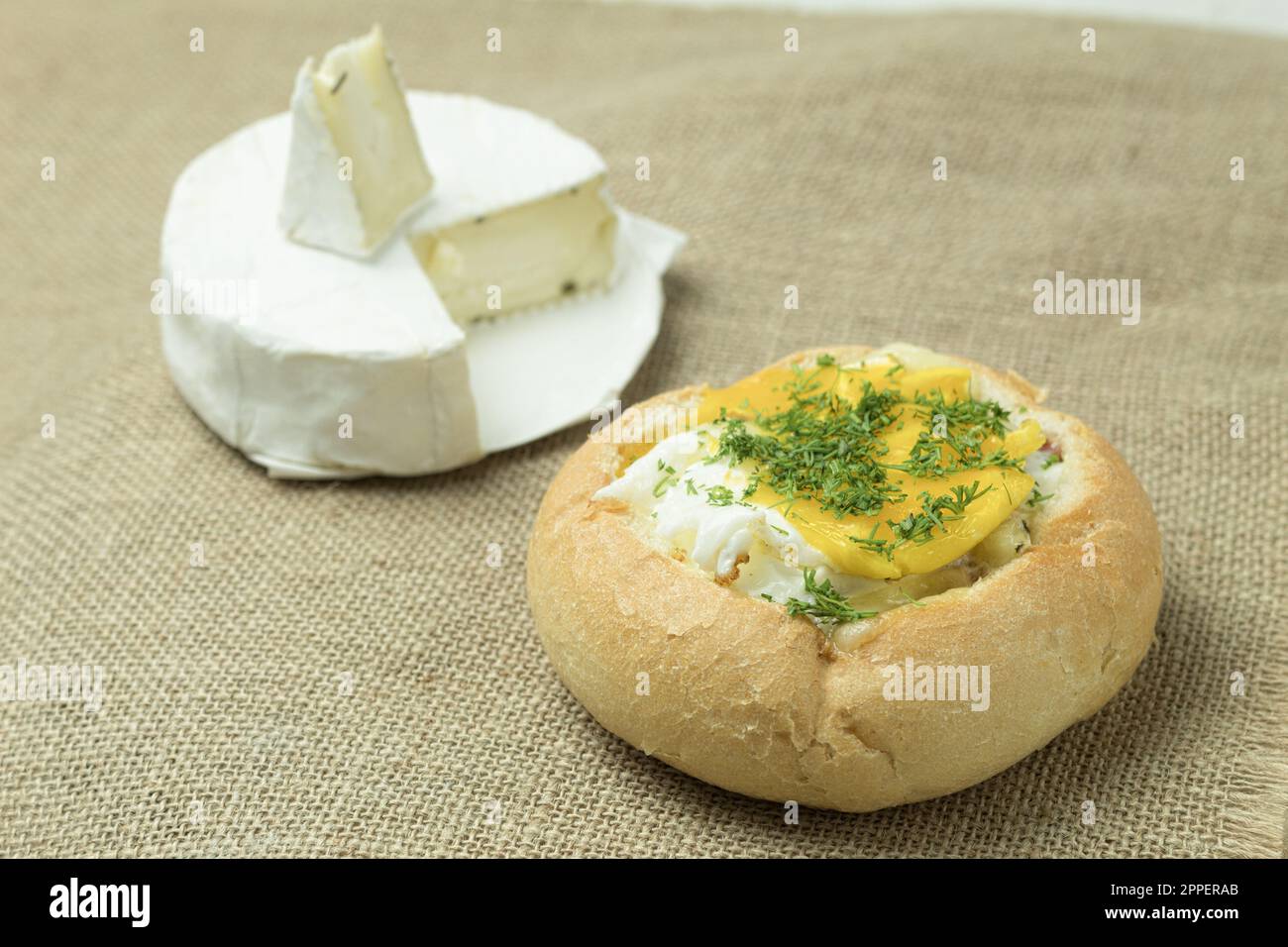 Brötchen mit Käse und Ei zum Frühstück. Sandwich mit Ei, Speck und Käse. Leckeres und gesundes Frühstück Stockfoto