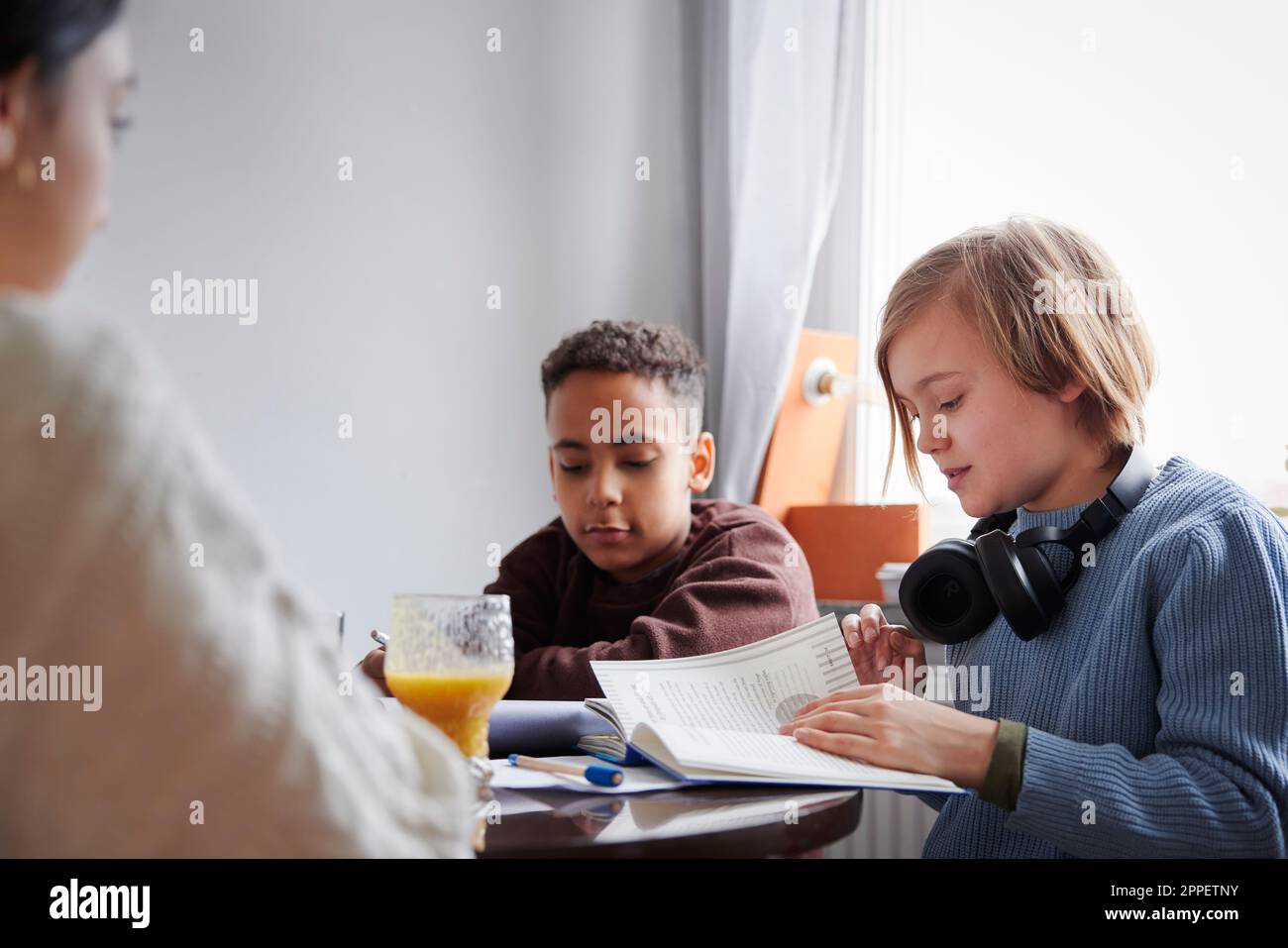 Zwei Jungs machen Hausaufgaben am Esstisch Stockfoto