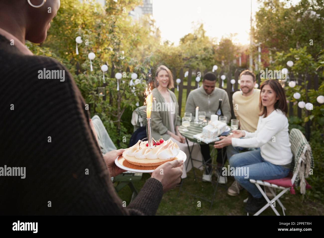 Fröhliche Freunde feiern im Garten Stockfoto