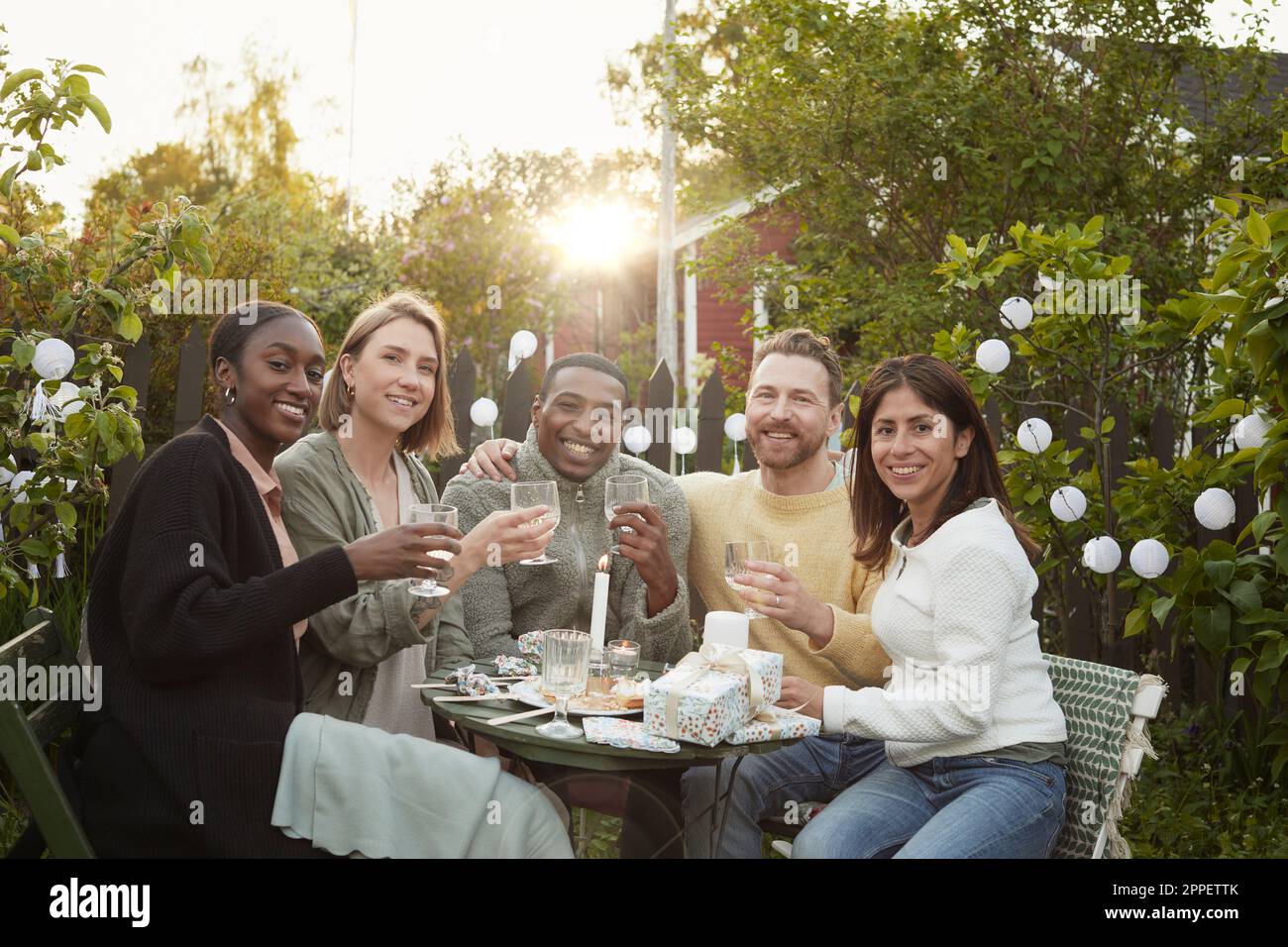 Fröhliche Freunde feiern im Garten Stockfoto