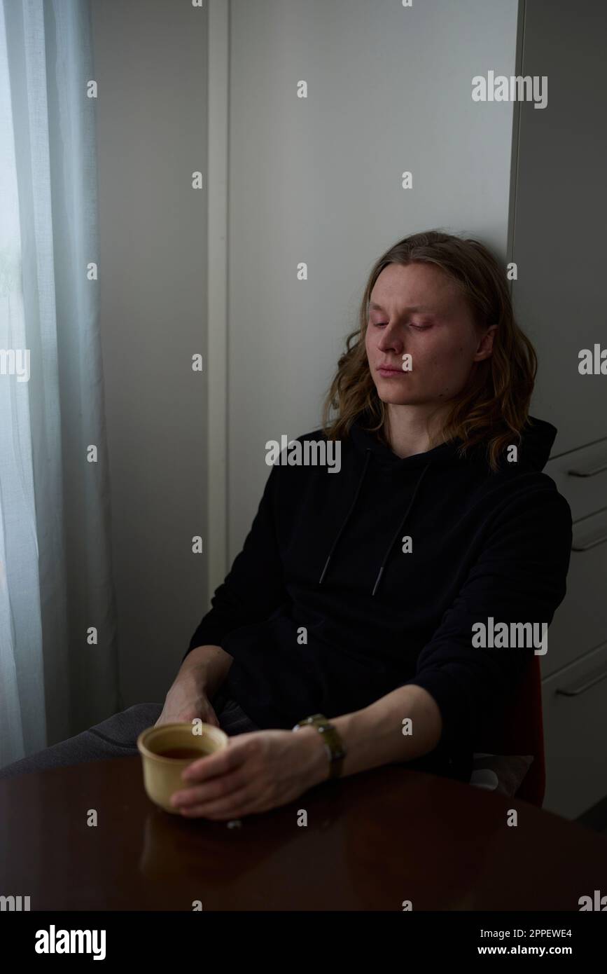 Traurige Frau, die mit einer Tasse Kaffee sitzt Stockfoto