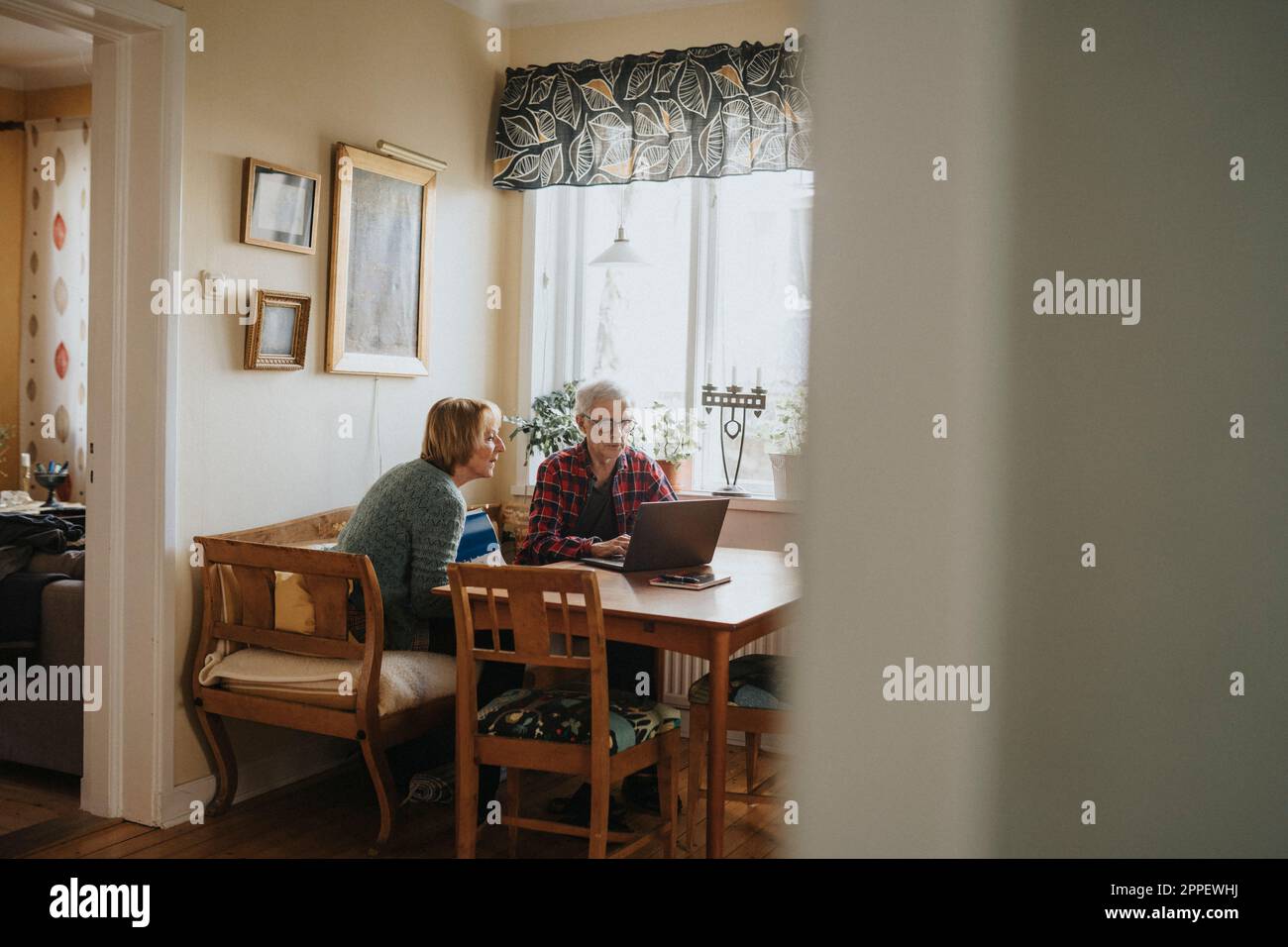 Älteres Paar mit Laptop zu Hause Stockfoto