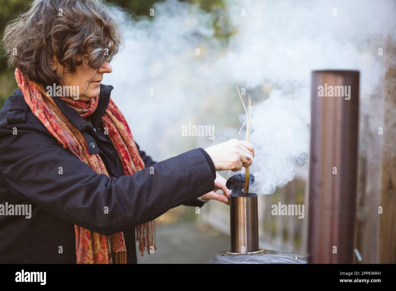 Eine Frau, die Feuer im Ofen macht Stockfoto