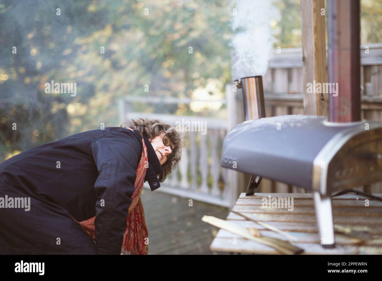 Eine Frau, die Feuer im Ofen macht Stockfoto