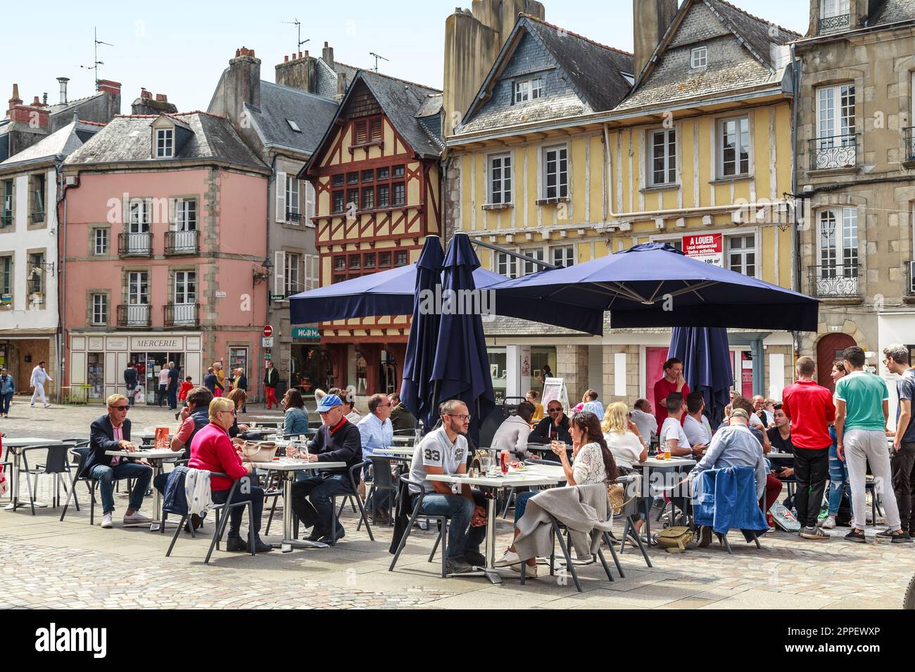 QUIMPER, FRANKREICH - 6. SEPTEMBER 2019: Unbekannte Menschen entspannen sich in einem Café auf einem der Plätze der Altstadt. Stockfoto