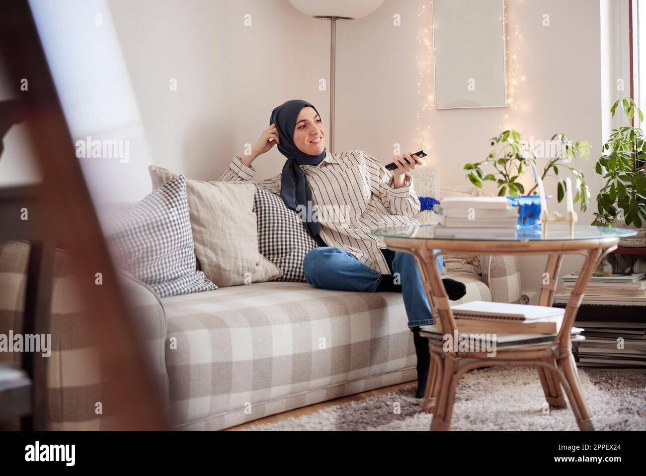 Frau sitzt auf dem Sofa im Wohnzimmer Stockfoto