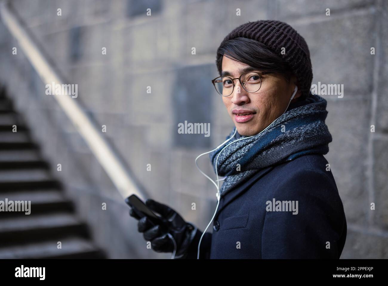 Attraktiver Mann mit Smartphone auf der Straße Stockfoto