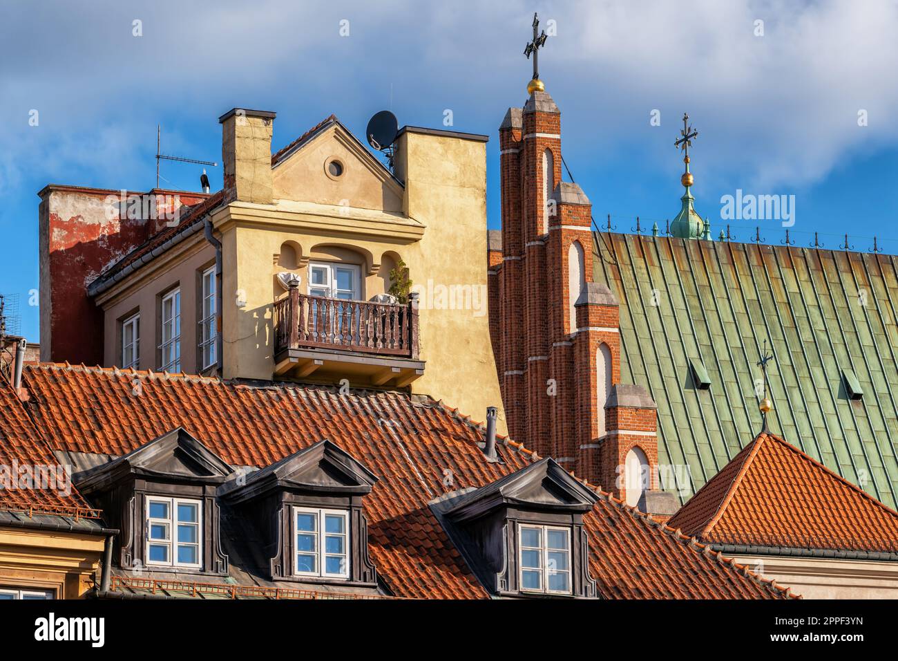Historische Architektur der Altstadt in Warschau, Polen. Im Mietshaus befindet sich ein Dach mit Dachfenstern und einem Dach der Erzkathedrale von St. John. Stockfoto