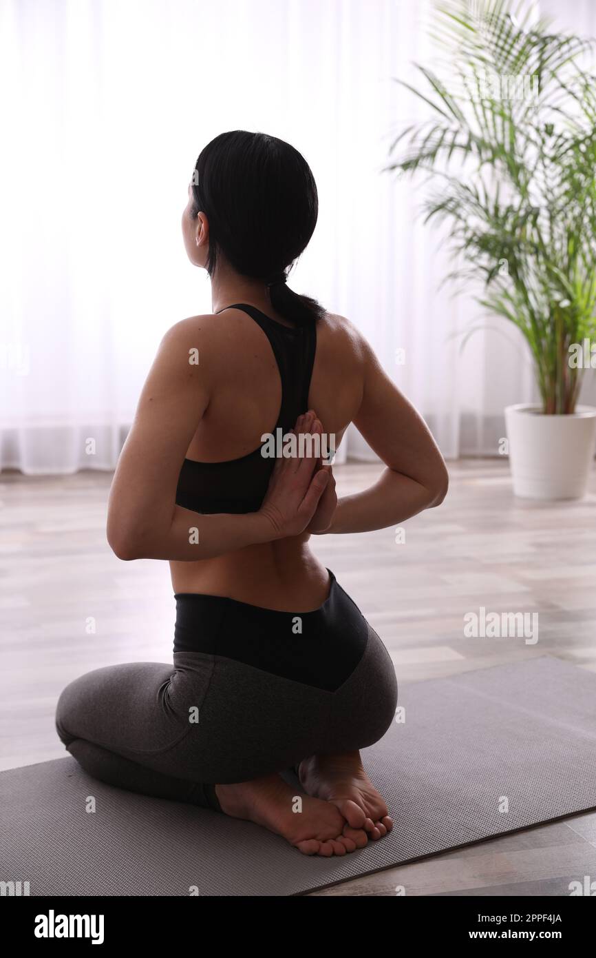 Junge Frau, die Seiza-Asana im Yoga-Studio praktiziert. Vajrasana-Pose Stockfoto