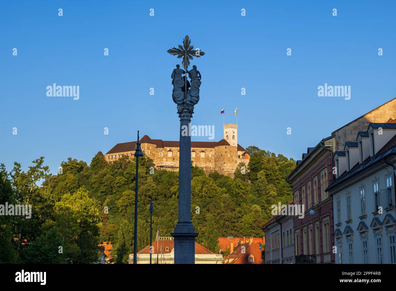 Dreifaltigkeitssäule bei Sonnenuntergang vor der Burg Ljubljana in der Stadt Ljubljana in Slowenien. Stockfoto