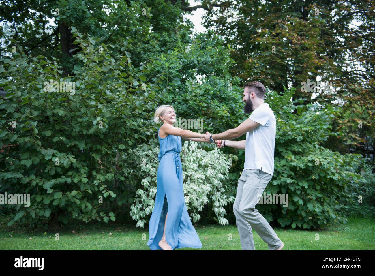 Ein junges Paar tanzt zusammen im Garten, Bayern, Deutschland Stockfoto