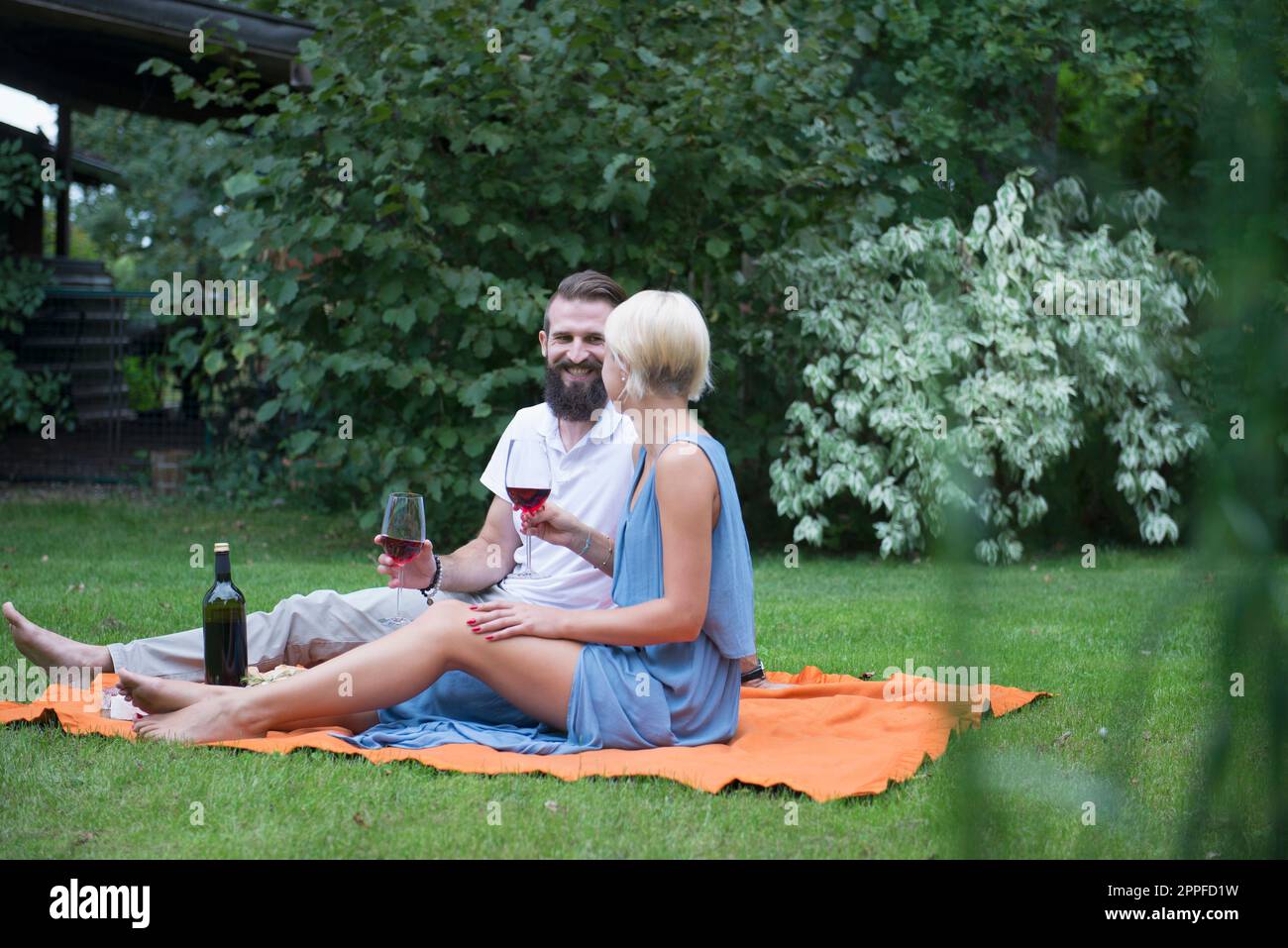 Ein junges Paar genießt Rotwein beim Picknick in Bayern Stockfoto