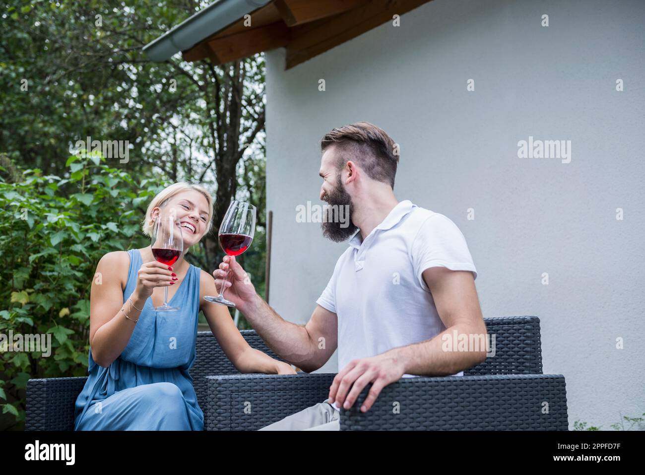 Ein junges Paar genießt Rotwein im Garten, Bayern, Deutschland Stockfoto