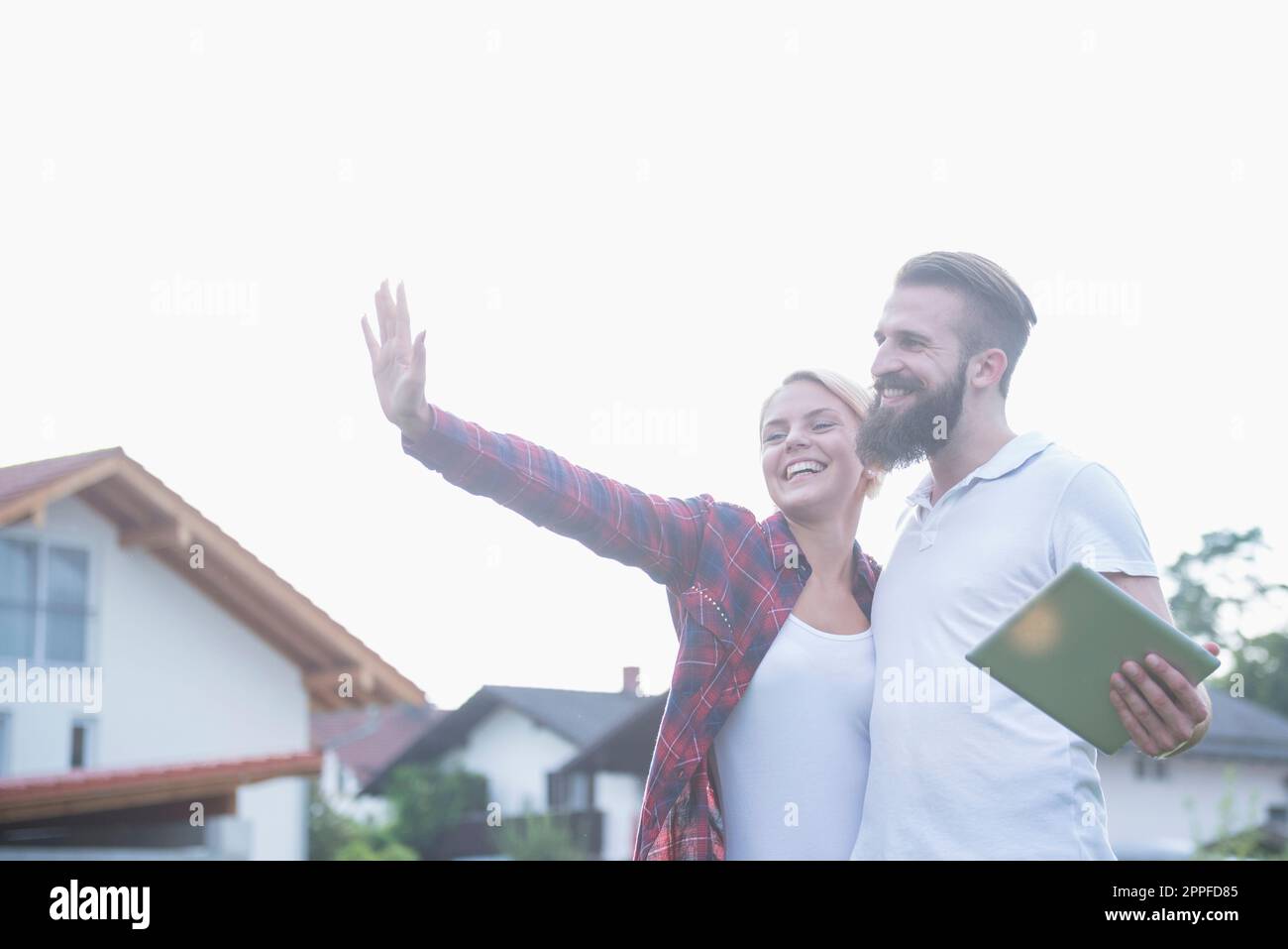 Glückliches junges Paar mit digitalem Tablet stellt sich sein zukünftiges Haus Bayern vor Stockfoto