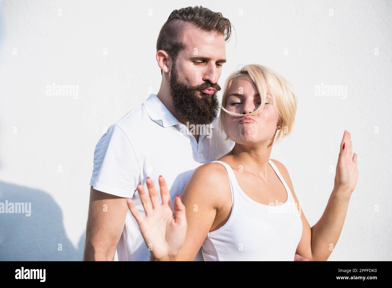 Junger Mann mit seiner verspielten Freundin, macht Schnurrbart mit Haaren, Bayern, Deutschland Stockfoto