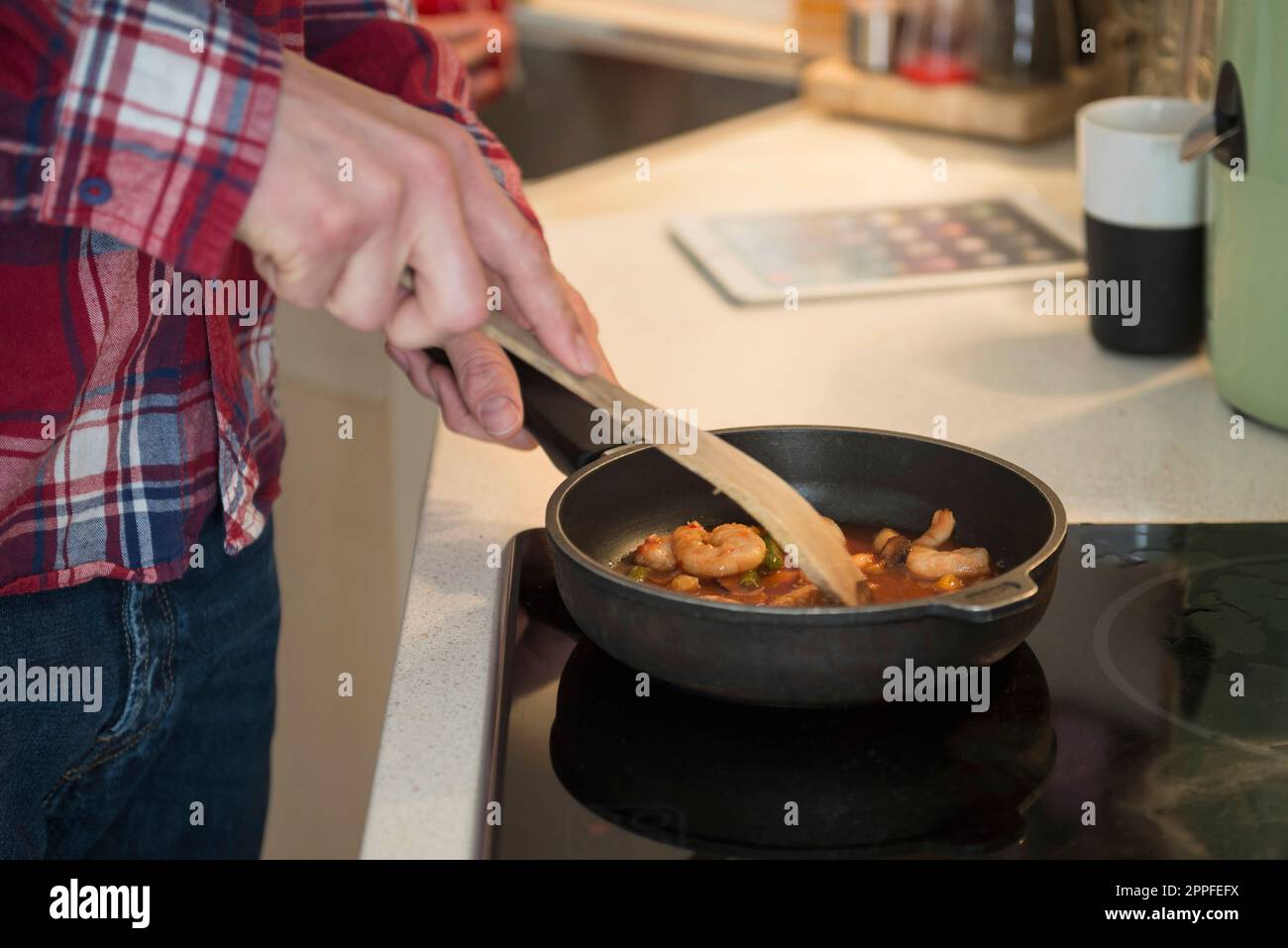 Mann bereitet Essen in der Küche zu, München, Bayern, Deutschland Stockfoto