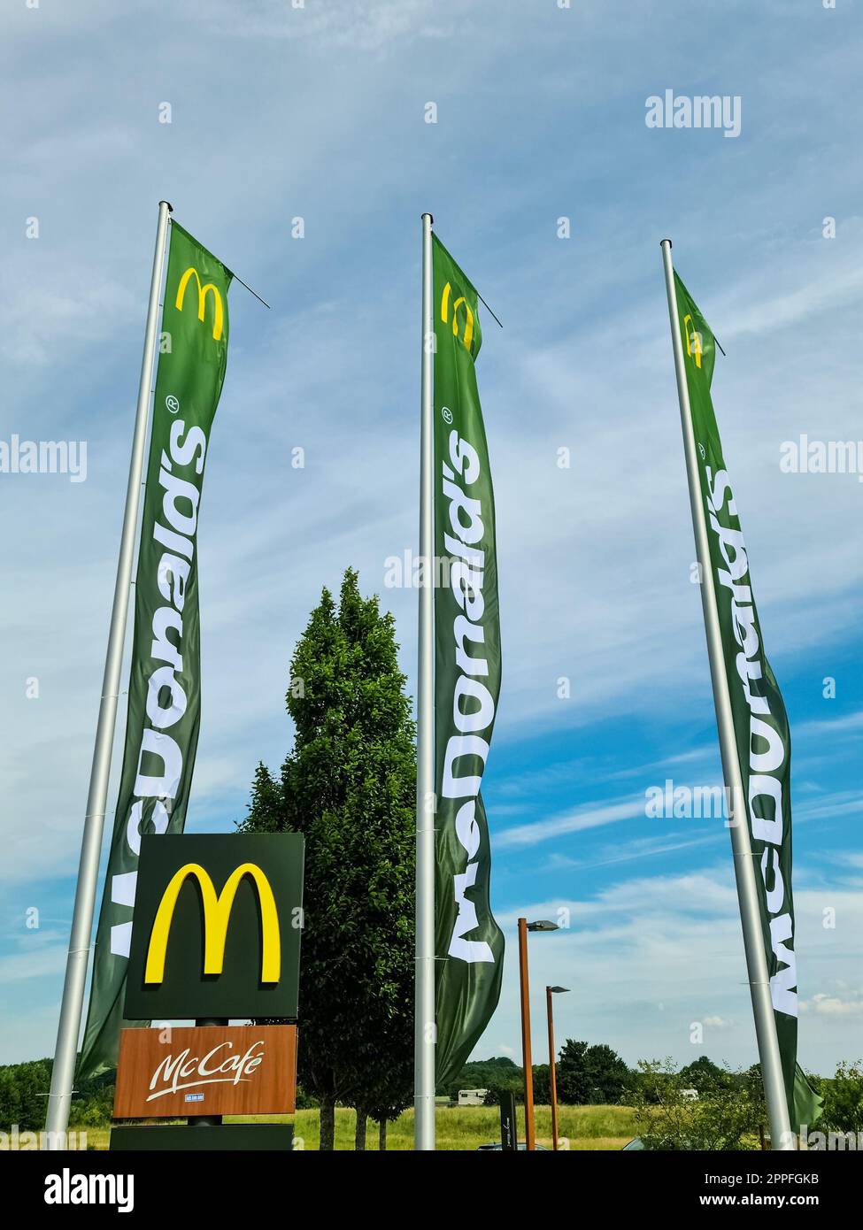 Kiel, Deutschland - 1. Juli 2022: Flaggen der Fast-Food-Kette MC Donalds vor einem Restaurant. Stockfoto