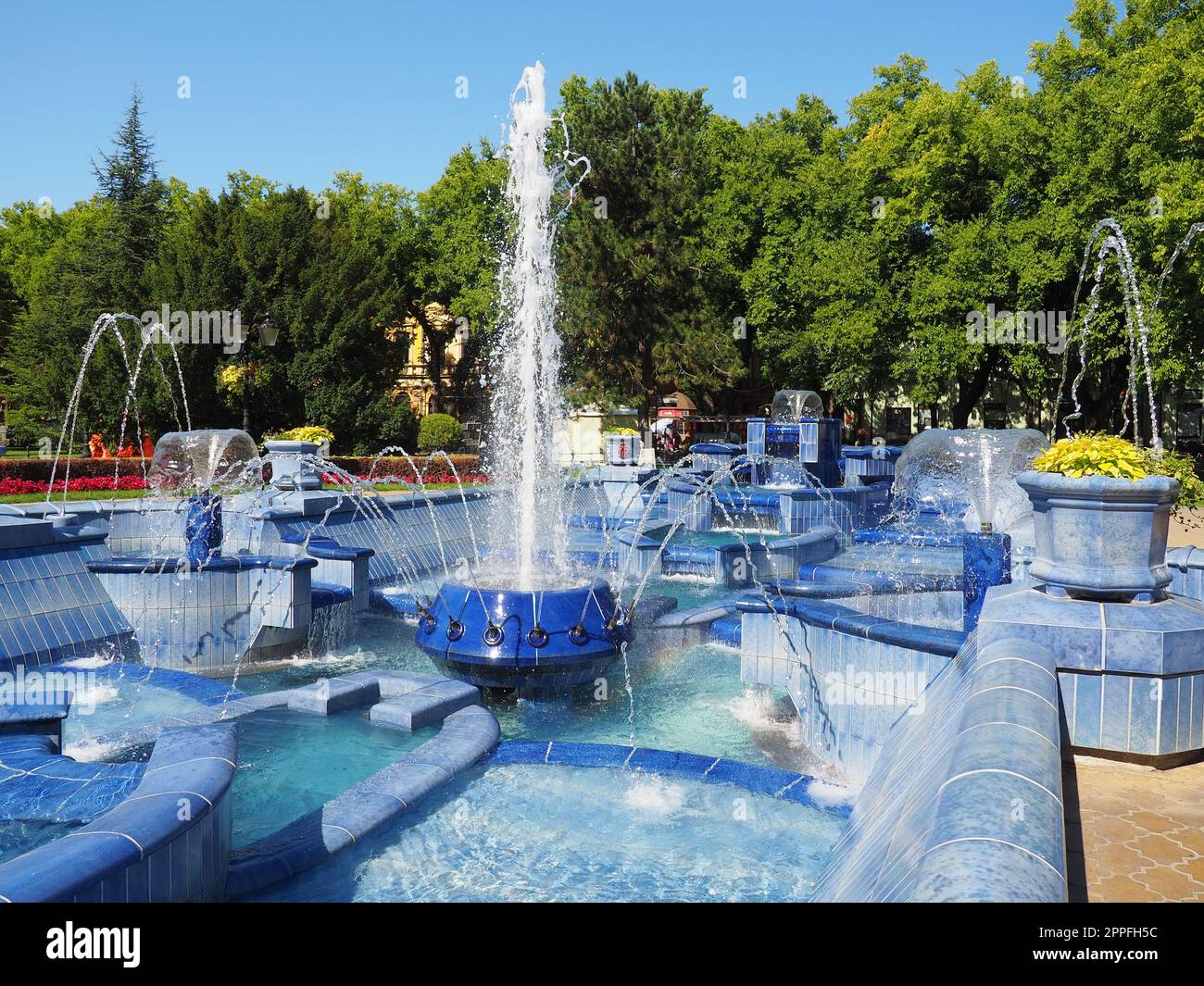 Subotica, Serbien 12. September 2021. Blauer Brunnen auf dem Platz neben dem Rathaus. Blaue Keramikteile mit Monogrammen. Ein funktionierender Brunnen mit Spritzwasser. Sommersonnentag am blauen Wasser Stockfoto