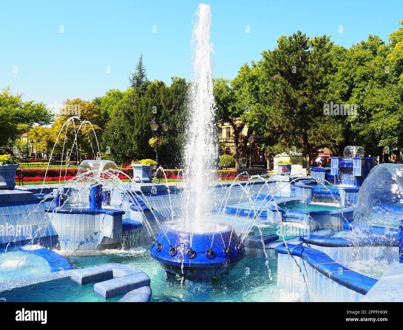 Subotica, Serbien 12. September 2021. Blauer Brunnen auf dem Platz neben dem Rathaus. Blaue Keramikteile mit Monogrammen. Ein funktionierender Brunnen mit Spritzwasser. Sommersonnentag am blauen Wasser Stockfoto