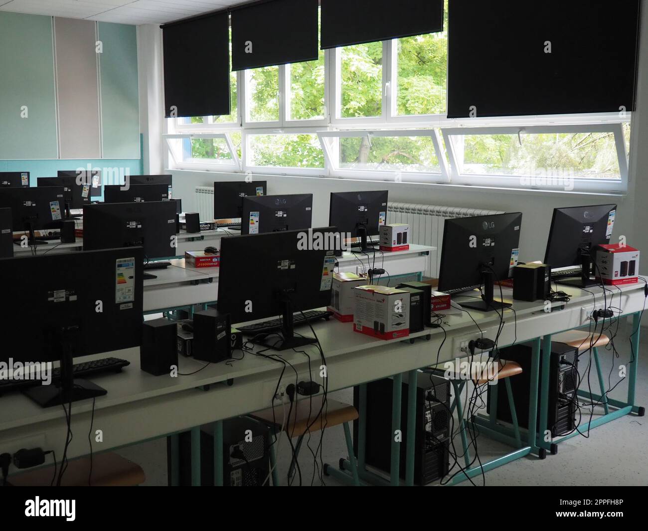 Sremska Mitrovica, Serbien, 15. Mai 2021 Computergruppe, die ordentlich in einem Computerlabor aufgestellt wurde. Computer, Monitore, Kabel im modernen Klassenzimmer der neuen Schule. Schreibtische für Schüler und Studenten Stockfoto