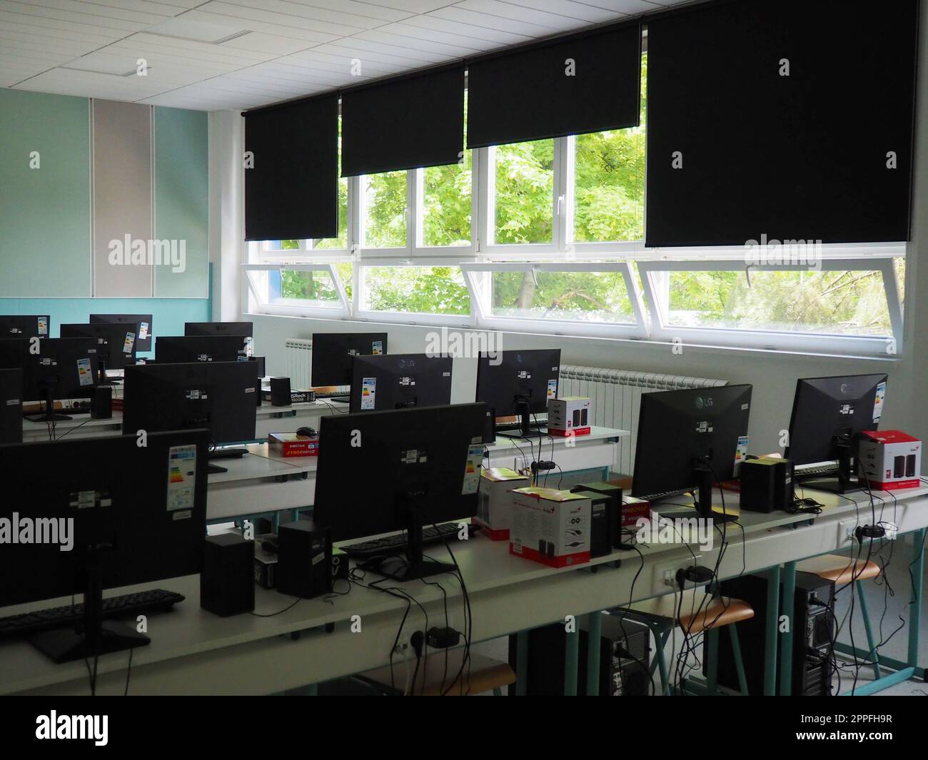 Sremska Mitrovica, Serbien, 15. Mai 2021 Computergruppe, die ordentlich in einem Computerlabor aufgestellt wurde. Computer, Monitore, Kabel im modernen Klassenzimmer der neuen Schule. Schreibtische für Schüler und Studenten Stockfoto