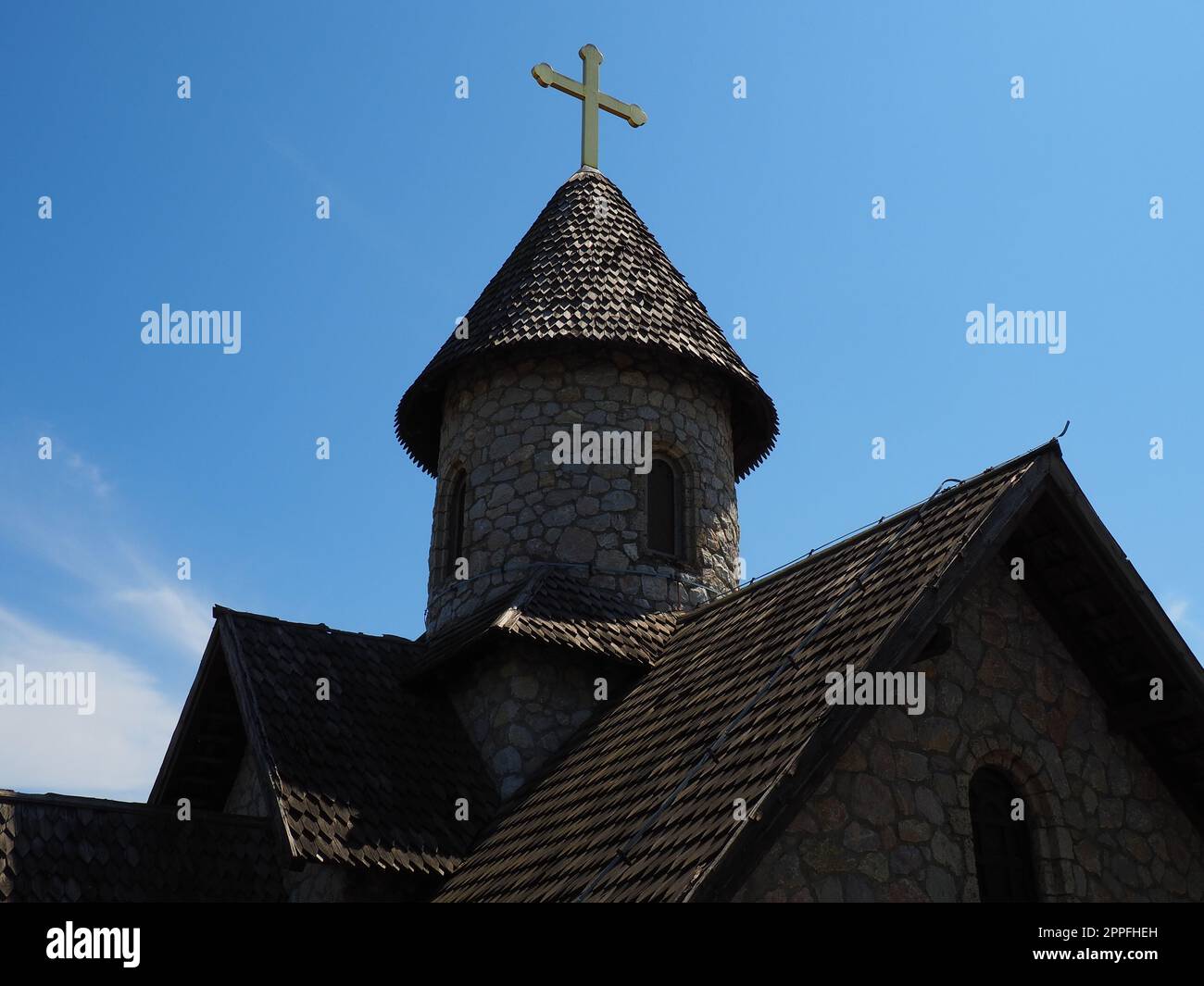 Steinorthodoxe Kirche im Ethno-Park. Religiöser Tourismus. Ein Gebäude aus Steinen mit einem Kreuz auf der Kuppel. Blauer Himmel Stockfoto