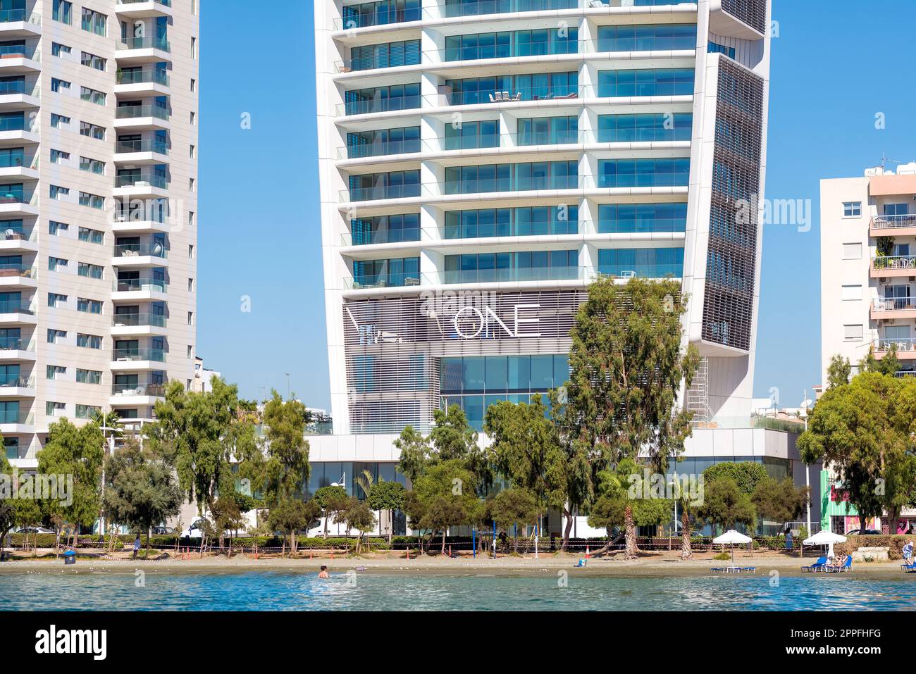 Limassol, Zypern - 16. April 2022: Opti Olympion B Strand und ein Limassol Wohnturm Stockfoto