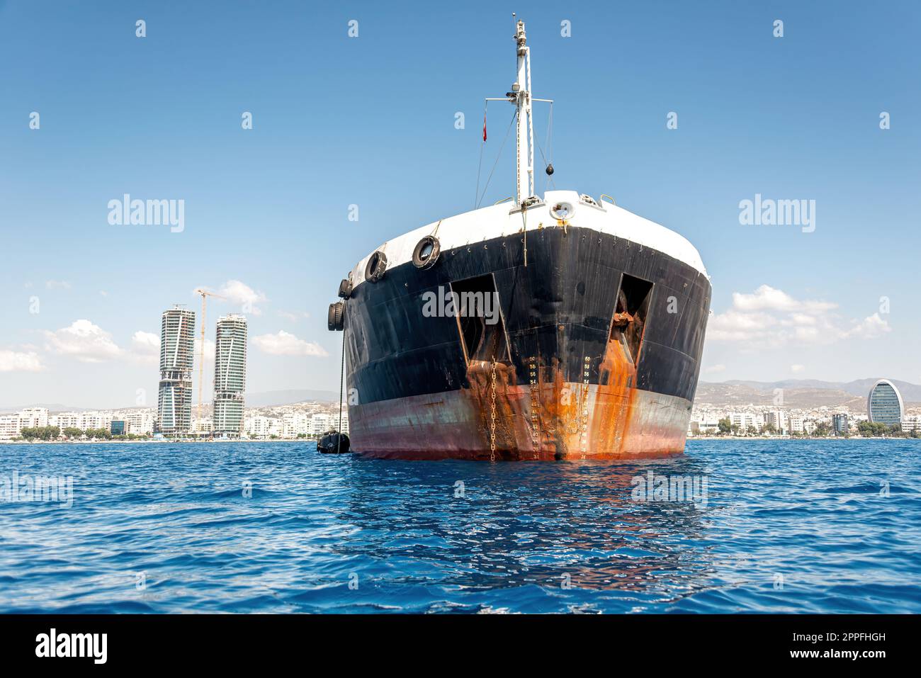 Ölprodukte-Tankschiff in der Akrotiri Bay mit Limassol-Skyline im Hintergrund. Zypern Stockfoto