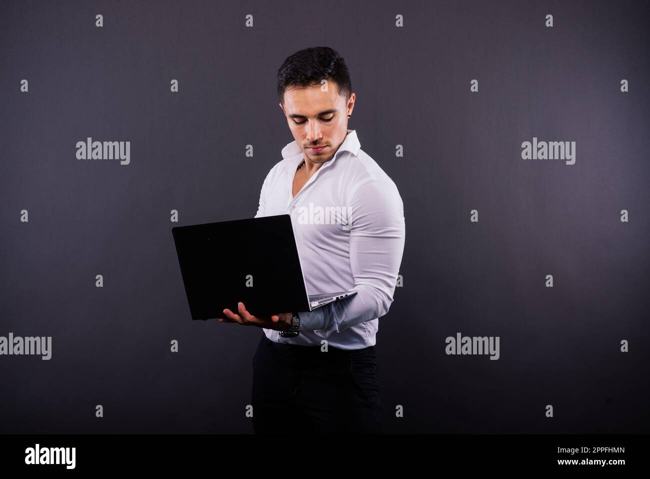 Fröhlicher junger Mann 20s in klassischem Hemd isoliert auf dunklem Studioporträt im Hintergrund. Stockfoto