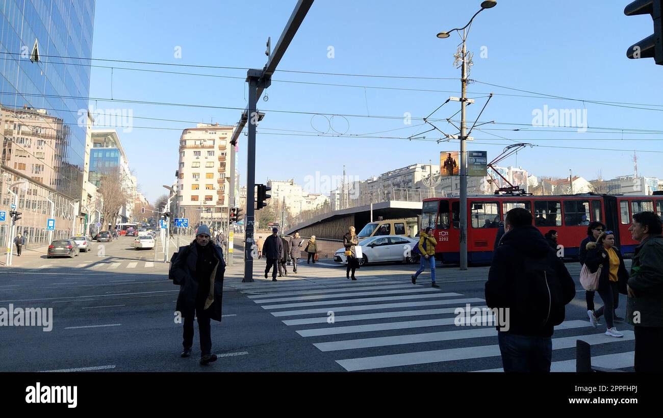 Belgrad, Serbien - 24. Januar 2020: Fußgängerüberquerung mit Menschen auf dem Slavia-Platz im Zentrum von Belgrad. Aktiver Verkehr, Fußgänger überqueren die Straße auf den weißen Zebrastreifen. Straßenmarkierung. Stockfoto
