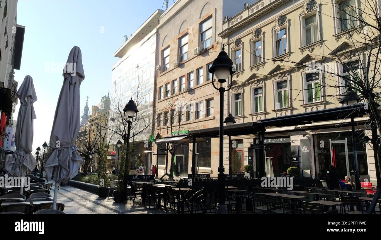 Belgrad, Serbien - 24. Januar 2020: Morgenstraße im Stadtzentrum. Die Leute hetzen sich um ihre Geschäfte. Straßencafés sind immer noch geschlossen. Tische, Stühle und Sonnenschirme. Stockfoto