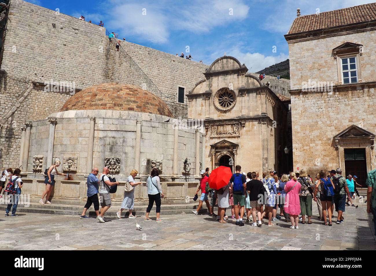 Dubrovnik, Kroatien, 08.14.2022. Großer Brunnen von Onofrio. Ein Maskaron, ein dekoratives Element in Form einer Maske mythologischen Charakters. Hohes Relief oder Skulptur. Menschen und Touristen Stockfoto