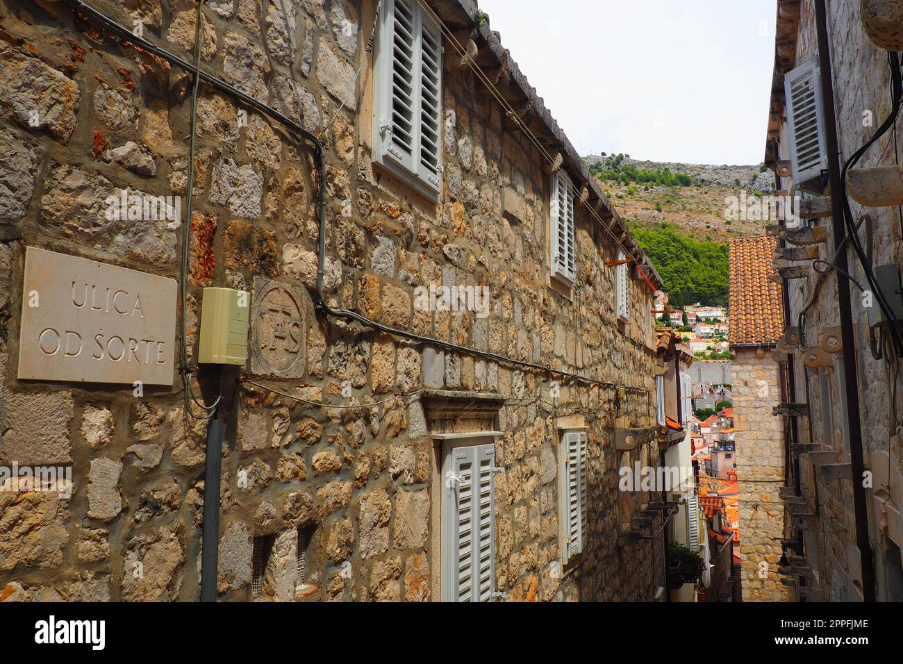 Dubrovnik, Kroatien, 08,14. 2022. Enge Gassen der antiken Stadt. Die Fassaden der Häuser sind aus Marmor und Stein sehr nahe beieinander. Fenster mit Fensterläden. Sommertourismus in der Adria. Stockfoto