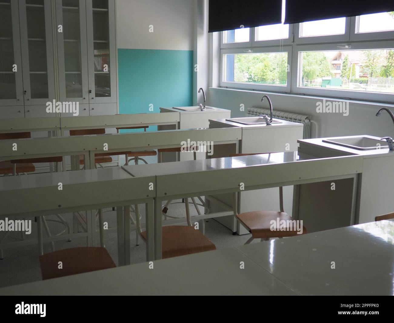 Chemiezimmer in einer modernen neuen Schule. Wunderschöne weiße Möbel mit Waschbecken und Waschbecken. Große Fenster mit Verdunkelungsvorhängen oder Jalousien. Leeres Klassenzimmer. Möbel und Schulausstattung Stockfoto
