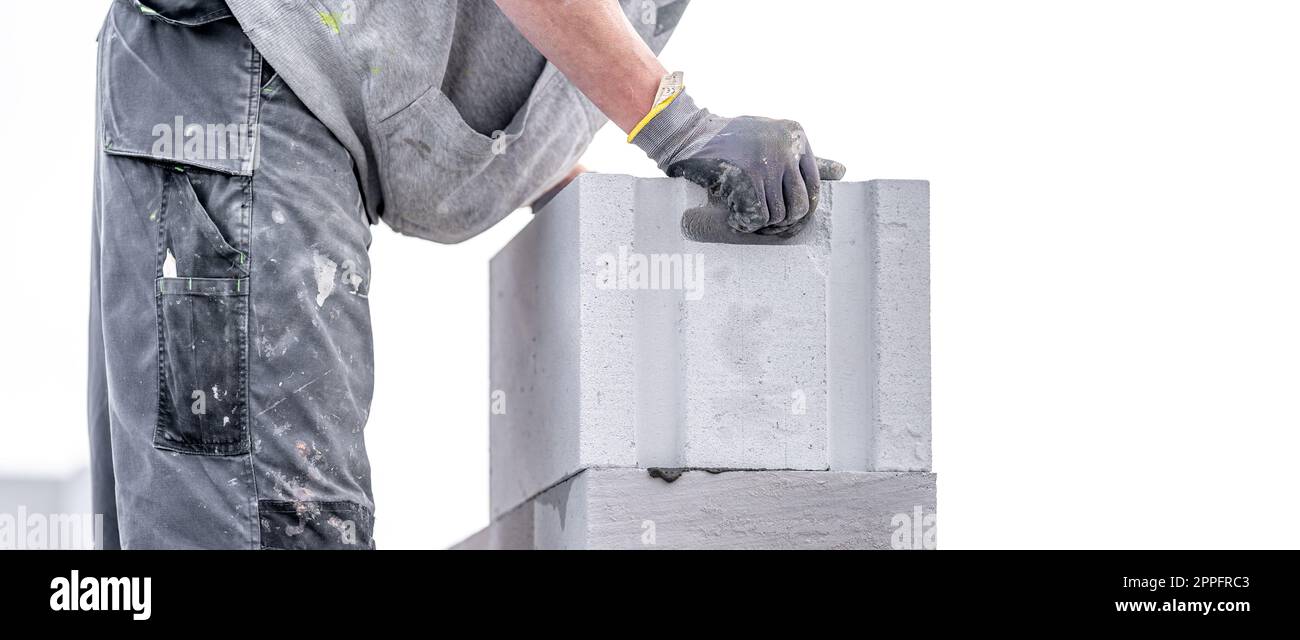 Ein Mauerwerk baut die Wand eines Gebäudes aus Betonziegeln und -Blöcken Stockfoto