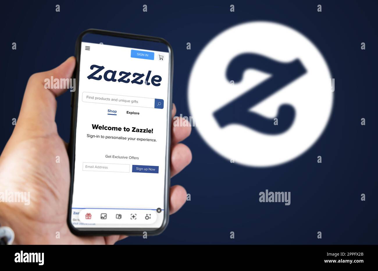 Hand hält ein Telefon mit der Zazzle-Homepage auf dem Bildschirm Stockfoto