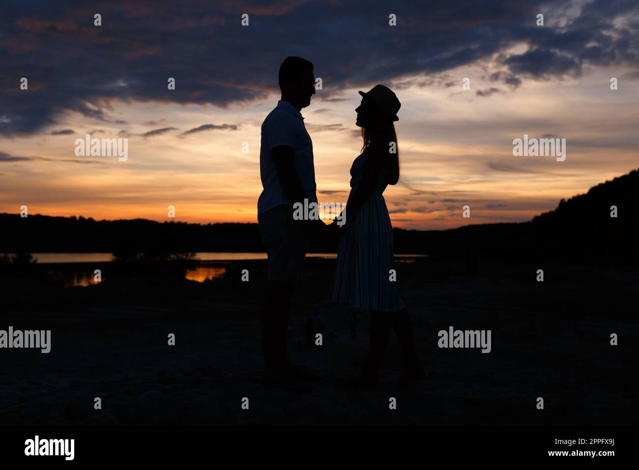 Ein Paar, das Händchen hält bei Sonnenuntergang Stockfoto
