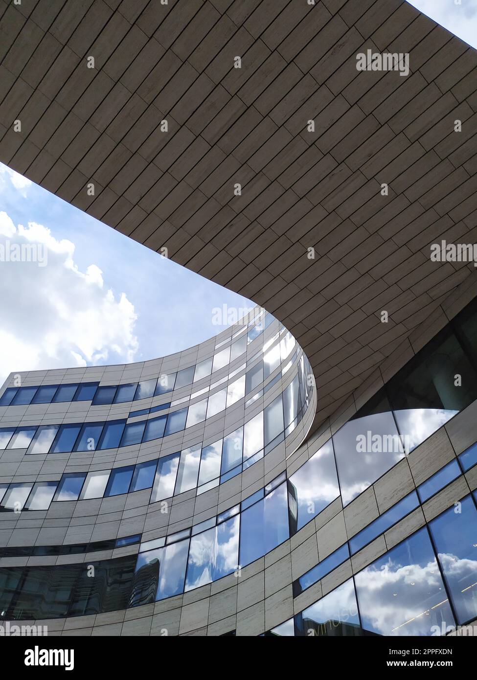 Düsseldorf, Deutschland - 16. Juli 2022: Moderne Architektur des DÃ¼sseldorfer KÃ¶bogen im Sommer zeigt eine attraktive und extravagante Glasfassade aus biologischem und geschwungenem Einkaufszentrum mit blauen Wolken Stockfoto