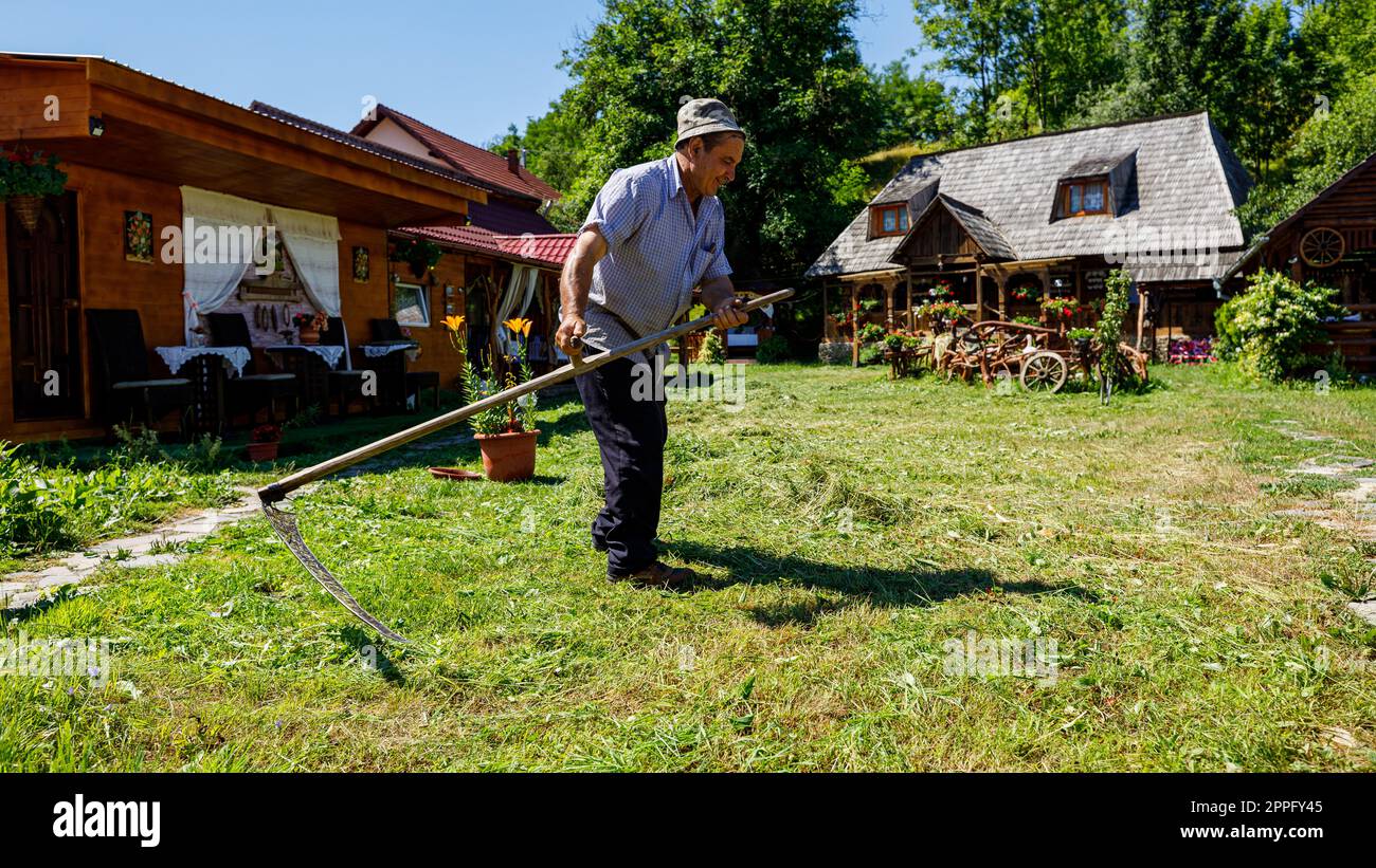 Ein Landwirt schneidet in Rumänien Gras mit einem Sinn Stockfoto